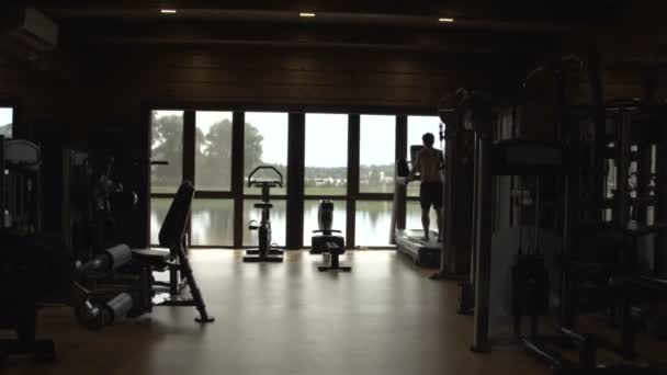 Jeune homme jogging dans la salle de gym — Video