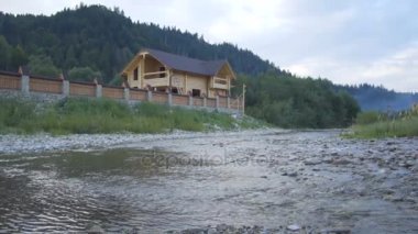 Bir dağ nehir orman ve çok güzel bir ahşap ev akar