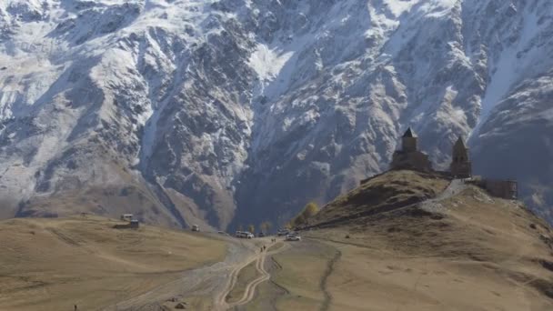Antigua iglesia de la Trinidad de Gergeti cerca del monte Kazbek, montañas del Cáucaso . — Vídeos de Stock