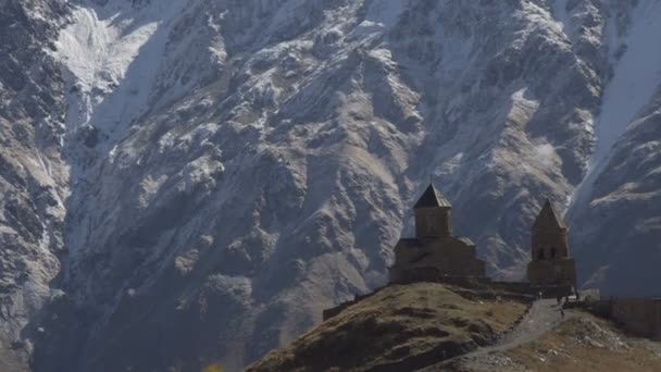 Antigua iglesia de la Trinidad de Gergeti cerca del monte Kazbek, montañas del Cáucaso . — Vídeos de Stock