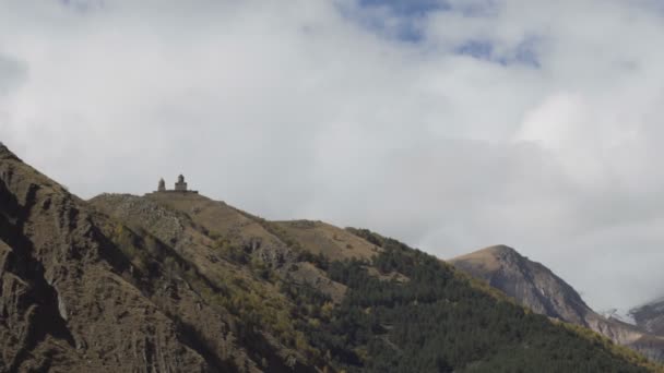 Antigua iglesia de la Trinidad de Gergeti cerca del monte Kazbek, montañas del Cáucaso . — Vídeos de Stock