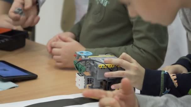 Van schattige kinderen bouwen gemotoriseerde robot op basisschool — Stockvideo