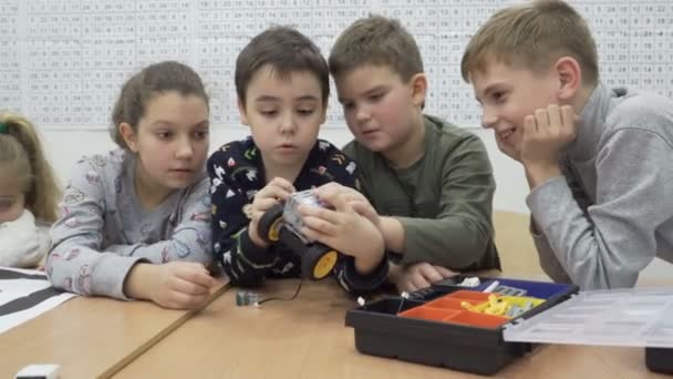 Aufnahme von niedlichen Kindern, die motorisierte Roboter in der Grundschule bauen — Stockvideo