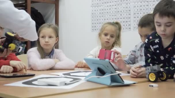 Prise de vue d'enfants mignons construisant un robot motorisé à l'école primaire — Video