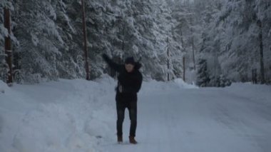 Kış manzarası. Genç adam kış ormanda koşuyor. 120fps