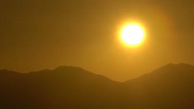 Deniz ve çöl Dağların üzerinden yükselen güneş