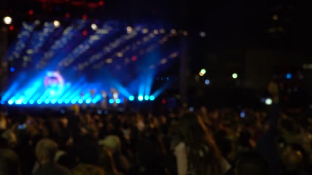 Tapete desenfocado de siluetas de multitud de conciertos frente a luces de escenario brillantes . — Vídeos de Stock