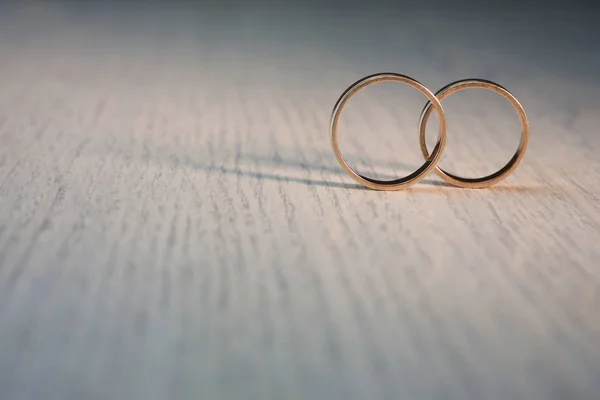 Dua cincin pernikahan di latar belakang kayu — Stok Foto