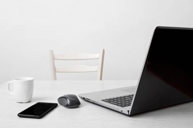Dizüstü bilgisayar, telefon, kahve Kupası ve bilgisayar fare ile temiz çalışma alanı
