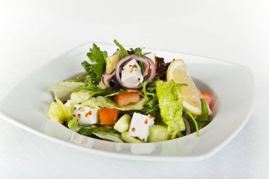 Taze sebzeli Yunan salatası, peynir ve siyah zeytin.