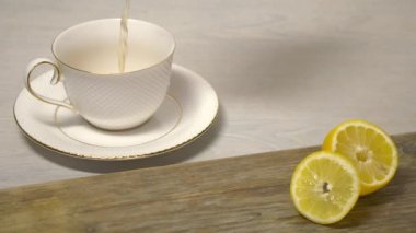 Çay beyaz çay fincan içine ahşap masanın üzerine dökülür varlık