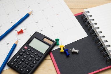 Üstten Görünüm defter, hesap makinesi, kalem ve takvim ahşap giy 
