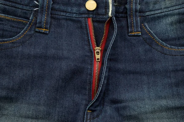 Довольно старые синие джинсы имеют полоску и красную текстуру молнии — стоковое фото