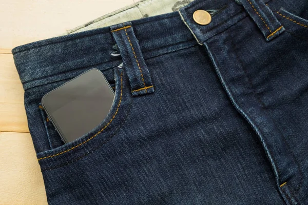 Ziemlich alte blaue Jeans haben Streifen und Smartphone in der Tasche — Stockfoto