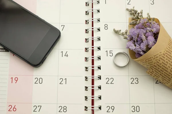 buket çiçek, akıllı telefon ve gümüş yüzük masaüstü calend koymak