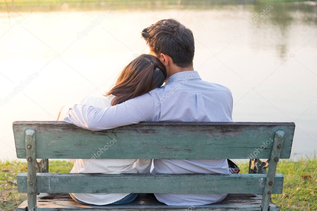 girlfriend and boyfriend sitting on bench and being hugging in p