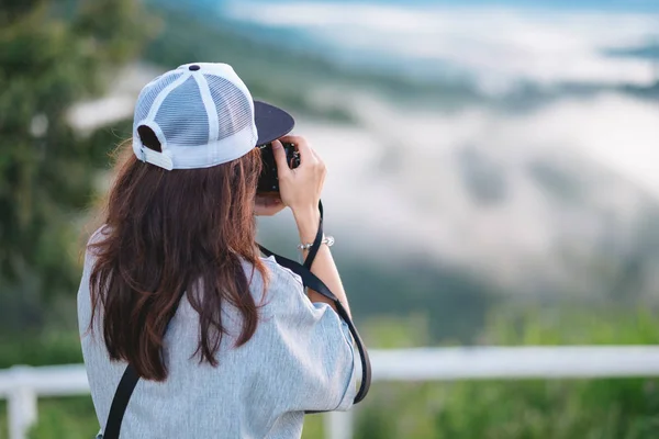 Fotógrafo asiático em pé no topo da montanha. ele usando a câmera f — Fotografia de Stock