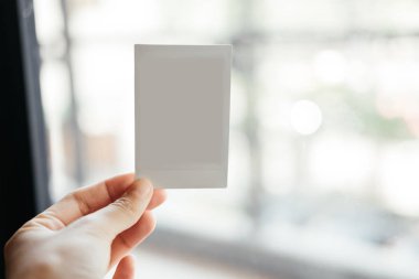 Önden Görünüm. el genç kadının boş Polaroid film tutmak. hav