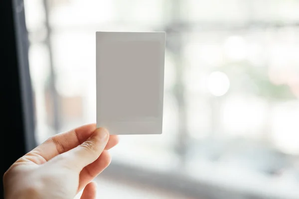 Önden Görünüm. el genç kadının boş Polaroid film tutmak. hav
