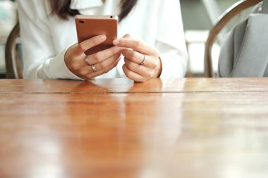 cep telefonu kullaranarak ve kahve kafede oturan Asya kadın el
