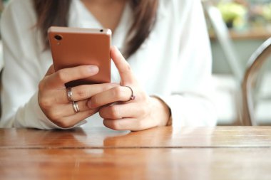 cep telefonu kullaranarak ve kahve kafede oturan Asya kadın el