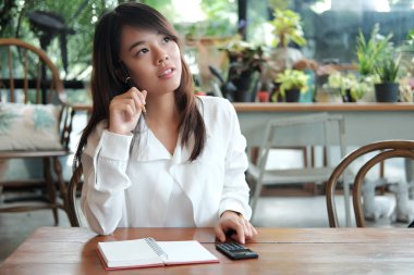 kalemle basılı tutup s bir şey düşünüyor genç öğrenci kadın