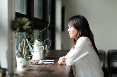 Yalnız cam kenarında oturan genç kadın. Ona üzgün ve w benziyorsun