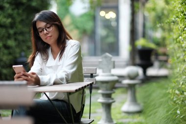 Yeşil ortak Bahçe ve h oturan gözlüklü genç kadın