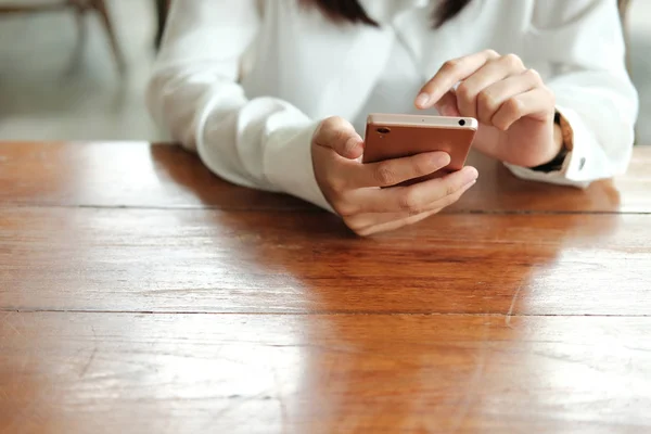 hand of asia woman using mobile phone and sitting in coffee cafe