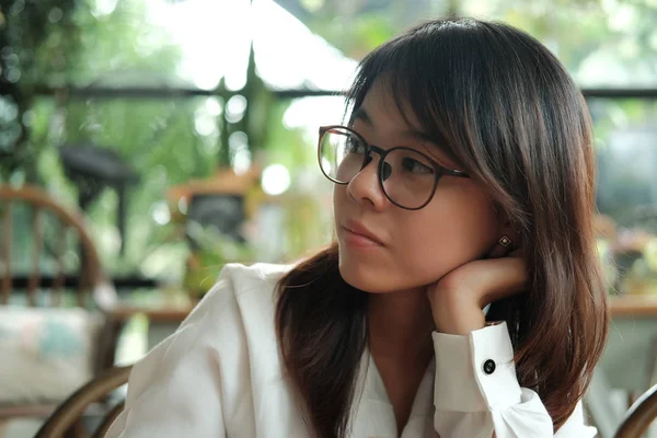 Joven mujer usando gafas pensando y esperando a alguien en el coff — Foto de Stock