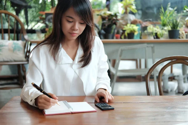 young student woman holding pen for writing on notebook paper an