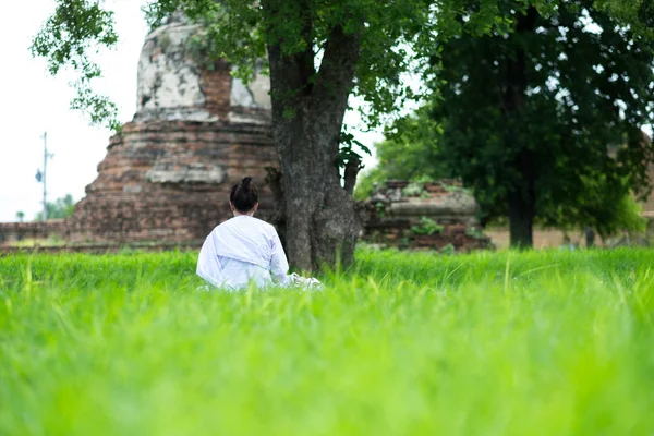 Vista para trás. jovem mulher ser meditação no campo de grama verde sob — Fotografia de Stock