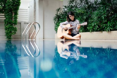 genç kadın gitar klasik el ve p yanında oturan tutun