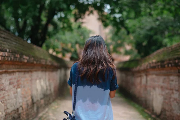 Vista trasera. joven mujer equipar azul camisa caminar solo en antiguo te —  Fotos de Stock