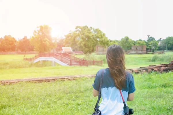 Genç kadın giyiyor kamera standı h çim alan cephesinde yalnız — Stok fotoğraf