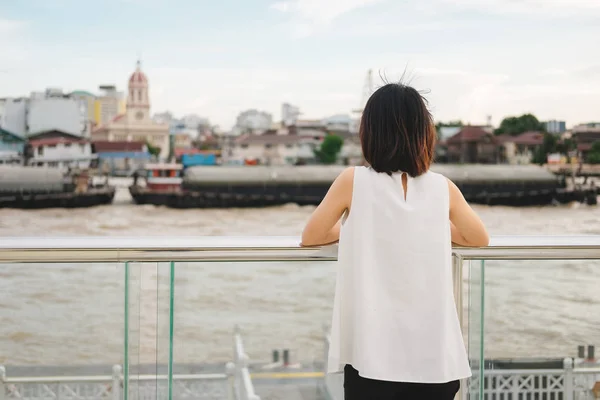 Genç kadın stand yalnız üzerinde riverside ve o sahne seyir vie — Stok fotoğraf