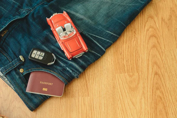 Vista superior. inserto de libro de pasaporte en pantalones de jean de bolsillo con coche de juguete — Foto de Stock