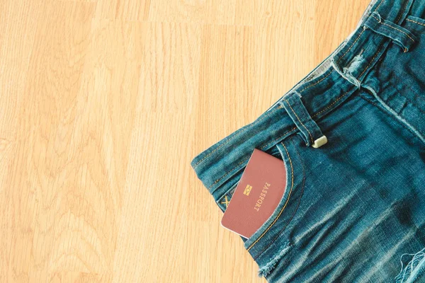Bovenaanzicht. paspoort boek invoegen op zak jean broek met houten — Stockfoto