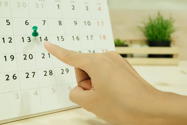 Kvinna punkt till dag 14 på carlendar hand placeras på trä tabl — Stockfoto