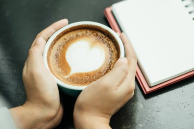 Üstten Görünüm. kadın her iki tarafında bir fincan bir dokunmatik el kullanın 