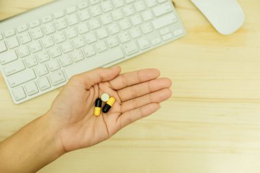 genç kadın tutun ilaç kapsül elini üzerinde klavye ve m vardır