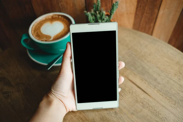iş kadının elini tut akıllı telefon. fincan kahve ile bir h var