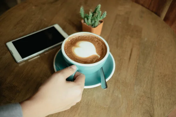 Top view. hand of business woman hold cup of coffee and has smar — Stock Photo, Image