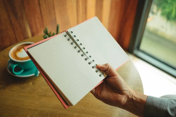 Pemandangan atas. tangan wanita bisnis memegang notebook kosong memiliki kecerdasan cangkir — Stok Foto