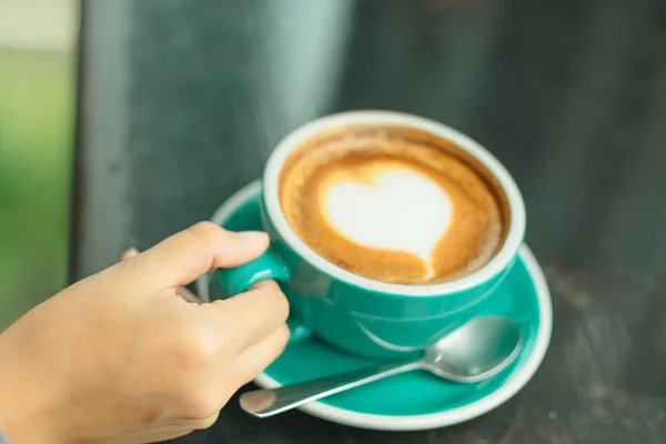 Hand van zakenvrouw houden cup met koffie geplaatst op de houten — Stockfoto