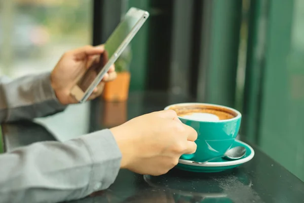 iş kadını kontrolden akıllı telefon sol taraftan tutun ve teçhizat kullanın