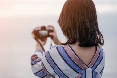 genç kadının tek başına kamera almak fotoğraf ile deniz backg tutun