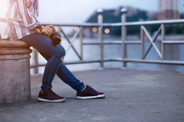 Mujeres jóvenes sostienen la cámara sentado solo con el fondo del mar. imagen — Foto de Stock