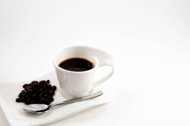 Beyaz arka plan kahve Kupası kahve çekirdekleri ile beyaz fl yerleştirilir