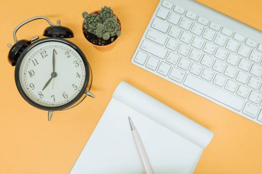Üstten Görünüm. saat, klavye, defter, kalem ve kaktüs yerleştirilir
